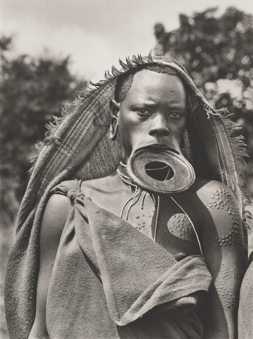 Scarification is carried out with sharp stones, knives, or razor blades. Ash is rubbed into the wound, promoting scar-tissue growth. Surma village of Regia, Omo National Park, near Maji. Ethiopia.