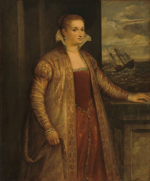 Shown from the knees up, a pale-skinned woman wearing rust-red gown under a sumptuous coat stands near a window, through which a sinking ship is shown in this vertical portrait painting. The woman’s body and head are angled to our right as she looks out at us with dark gray eyes. She has a nose with a rounded tip, a thin upper and full lower lip, and a slight double chin. Her red hair is pulled back and a braid wrapped around the back of her head. She wears a pearl and gemstone earring in the ear we see and a short, white pearl necklace. The bodice of her dress has a square neckline with black lines creating a vegetal pattern on the white fabric. That fabric continues up the sides of her chest and around her neck so a ruffle along the top flares out from her chin line. Letters along the inner edge of the fabric read “AV” to the left and “DIM+T” to the right. A gold jeweled belt encircles her waist, and one end hangs down the front of her long skirt, which is painted with a sheen suggesting velvet. The woman’s jacket is sand-brown, and it falls straight and heavy from her shoulders. The sides of the front opening, sleeves, and shoulders are decorated with knotted designs in brick red. Lace peeks out of each cuff, and the woman holds the coat belt loosely in her right hand, to our left. The wall behind her is dark stone, and her other hand rests on a stone ledge in front of the window. Through the opening is a stormy sky, choppy sea, and a masted ship listing hard to our left.