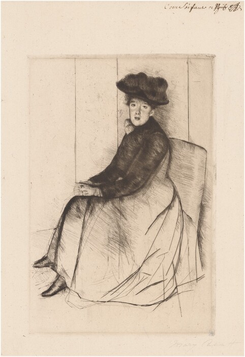 The image depicts a seated woman wearing a large coat and skirt. She is seated with her body angled to the side, head turned slightly towards the viewer. The woman has delicate facial features, with her hair covered by a fluffy hat. Her hands are resting in her lap as she sits on a wide chair. She is not wearing any visible jewelry or holding any objects. The background features simple vertical lines resembling a plain interior wall, creating a minimalist setting.