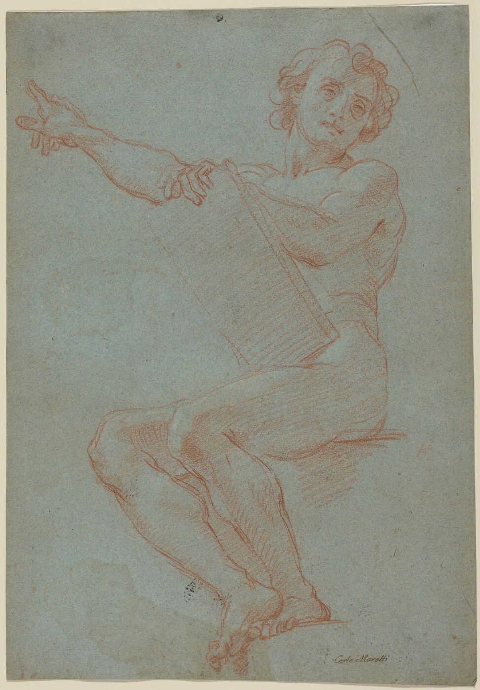 The image depicts a male figure in a seated position, facing forward. The figure is drawn in a dynamic pose, with their torso turned slightly to the left. The person's head is tilted to the right, looking upwards. The face shows defined features such as cheekbones, a jawline, and a nose. The person has short to medium wavy hair. The figure appears muscular and is drawn nude. The right hand holds a large rectangular object, while the left arm extends outward with the hand pointing forward. There are no visible accessories or items being held. The background is a plain blue-gray textured surface, with the figure and objects outlined in a reddish-brown hue.