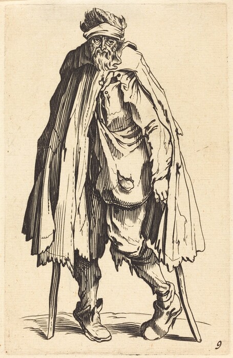 The image shows a man standing with a slight hunch, using a crutch under each arm for support. He has rugged facial features with a long, unkempt beard and bushy eyebrows. He has thick, disheveled hair and wears a headband or turban. His clothing is loose and tattered, including a long cloak, layered garment, patched pants, and worn shoes. The background is a plain surface.