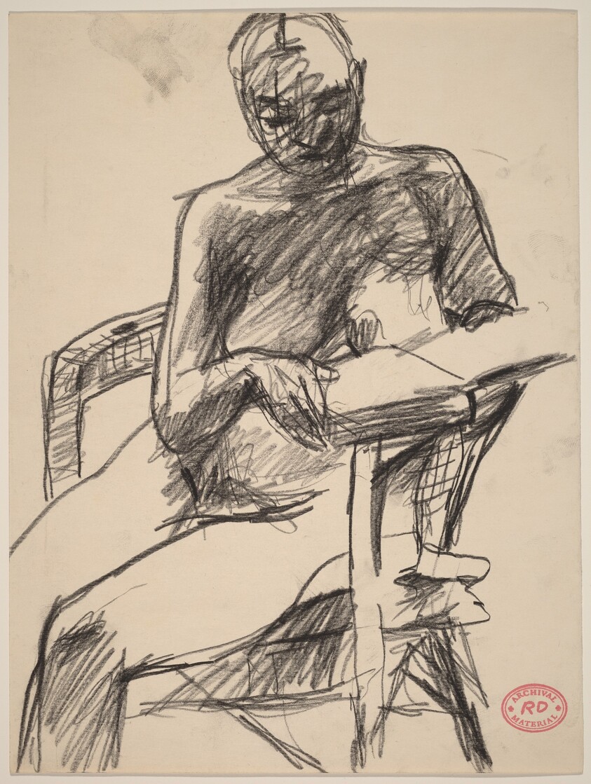 Untitled [nude seated in an armchair reading a book]
