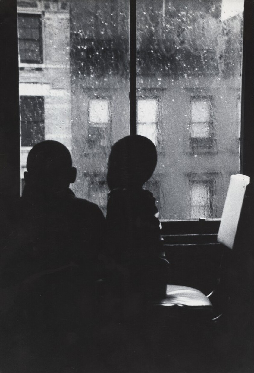 Two Boys Looking Out a Window on a Rainy Day