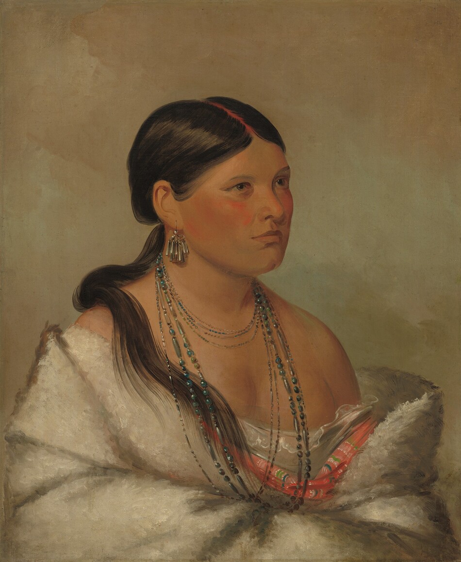 Shown from the waist up, a Shawano woman with medium-brown skin sits angled to the right and looking off in that direction in this vertical portrait painting. She has broad, flushed cheeks, light brown eyes, a cleft chin, and her lips are closed. Her black hair is parted down the middle and tied at the base of her head. A ponytail falls over one shoulder, and her part is painted red. She wears an earring made up of a cluster of long, conical silver tubes in the ear we can see. At least nine strands of delicate, blue-toned beads encircle her neck, some falling to the hollow of her throat and some reaching down her chest. Her shoulders are bare as a lace-edged chemise, carnation-pink fabric striped with blue, green, and white, and a thick white fur or fleece wrap are gathered around her arms, which appear to be crossed in front of her belly. The background is mottled with muted mauve pink and smoky turquoise blue.