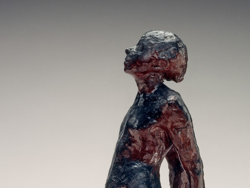 A young, nude girl is roughly modeled with glossy navy blue and wine-red beeswax in this freestanding sculpture. She faces our left in profile in this photograph. Her weight rests on her left foot, closer to us, and her other leg extends long, the foot turned out at an angle. Her hands are clasped behind her back, and her round belly projects from her swayed hips. Her head is tipped back and her eyes closed. She stands on a double pedestal. A crack runs across one corner of the top, white, square plaster pedestal. A wider wood pedestal is below.