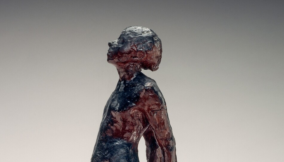 A young, nude girl is roughly modeled with glossy navy blue and wine-red beeswax in this freestanding sculpture. She faces our left in profile in this photograph. Her weight rests on her left foot, closer to us, and her other leg extends long, the foot turned out at an angle. Her hands are clasped behind her back, and her round belly projects from her swayed hips. Her head is tipped back and her eyes closed. She stands on a double pedestal. A crack runs across one corner of the top, white, square plaster pedestal. A wider wood pedestal is below.