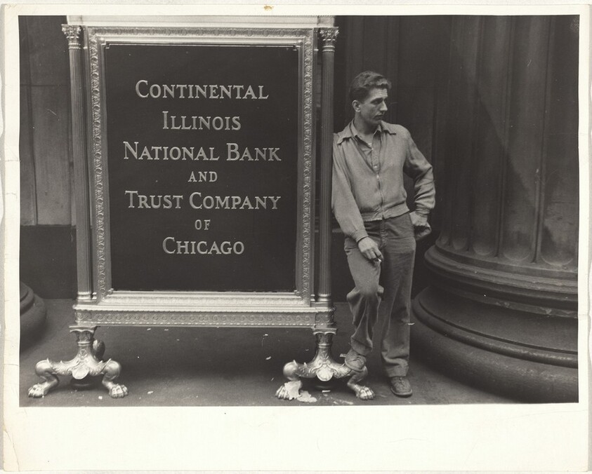 Man leaning on bank sign--Chicago