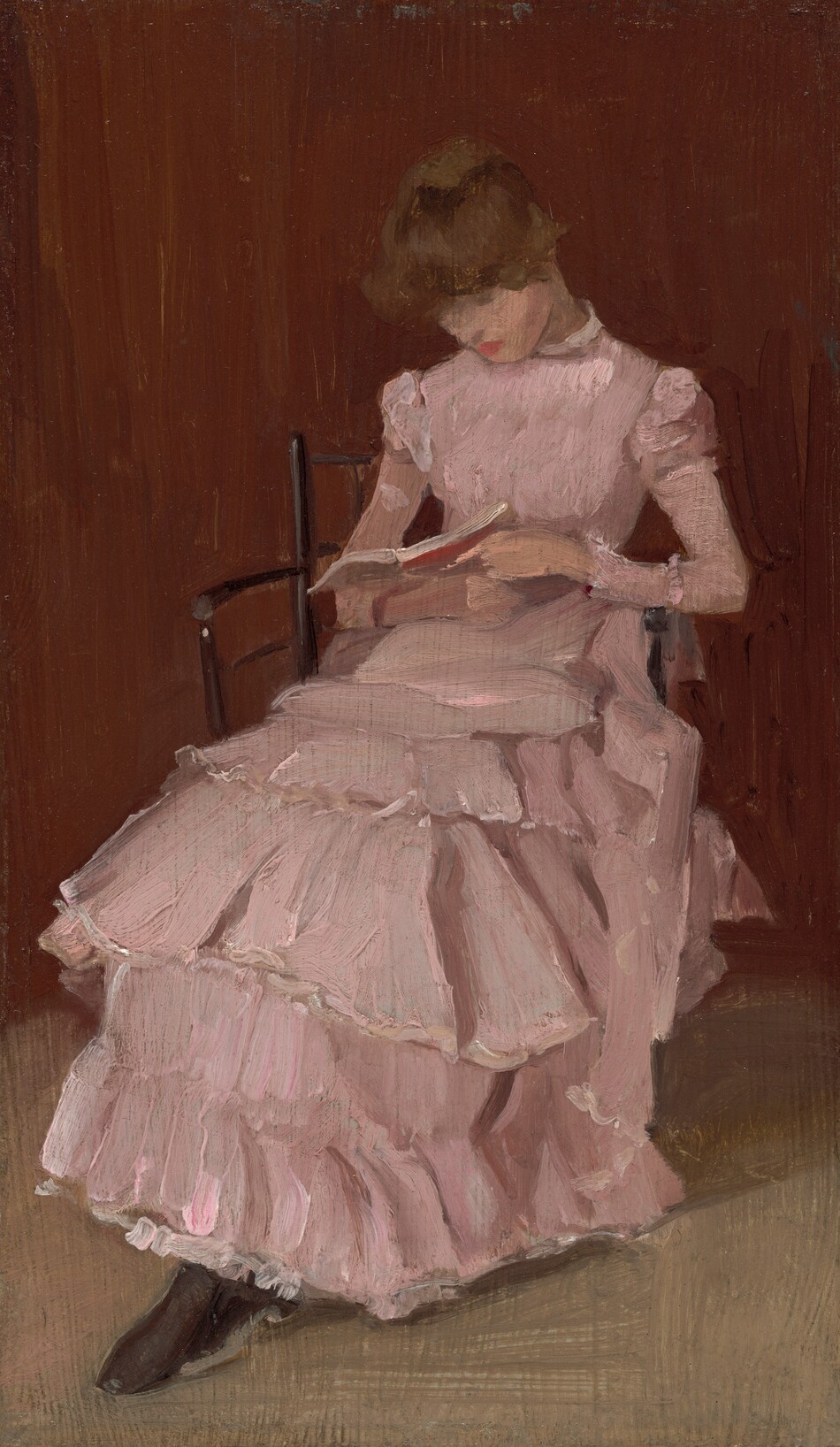 This painting shows a woman seated on a chair, looking down at a book she holds. She has light skin, short, wavy brown hair, and bright pink lips. She is turned slightly to the right, and most of her features are unclear. She wears an ornate pink dress with ruffles down the skirt, a high collar, and slightly puffed sleeves. The wall behind her is a reddish-brown color, while the ground is light gray. The brushstrokes in the painting are thick and visible.