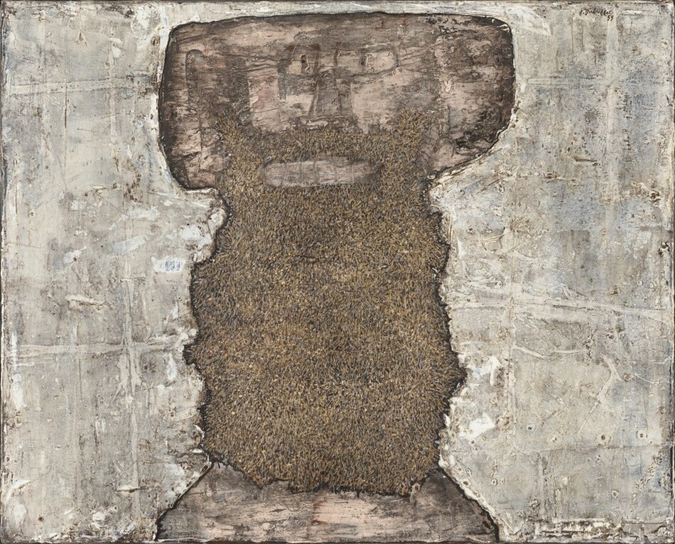 An upright, roughly rectangular, earth-brown and peachy-tan shape with ragged edges is at the center of this horizontal, abstract painting. Slowly we realize this central shape is a stylized face and long beard in the shape of a thick, capital letter T. Blocky ears straight across from rectangular eyes and a sketchily drawn nose create the wide crossbeam on the T. There is a peach smudge for the mouth and another band along the bottom of the painting, presumably representing skin on the chest. The rest of the central, dark area, a beard, is textured with sand and clay brown. The areas around the face and beard are streaked and daubed in with fog gray, pearl white, and pale tan. The artist signed and dated the work in the upper right corner, “J. Dubuffet 59.”