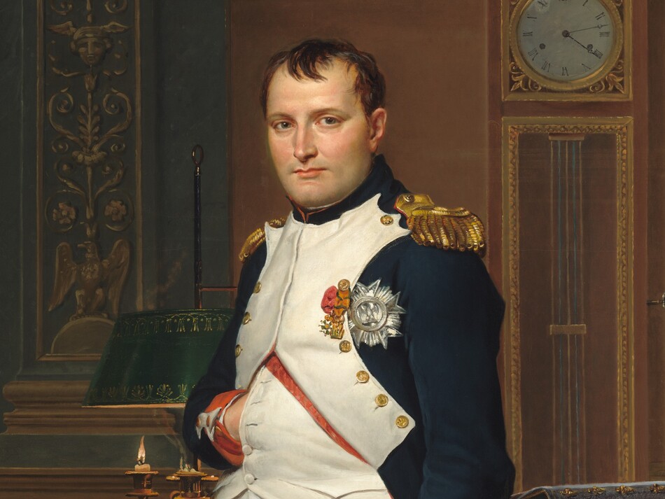 A man with pale peach skin and dark hair wears a military uniform and stands in front of a desk in this vertical portrait painting. He nearly fills the composition so seems close to us, and he looks directly at us. His body is angled slightly to our left and he tucks his right hand, on our left, flat against his chest between the buttons of his jacket. His navy-blue waistcoat is white along the front where it is fastened with brass buttons along his chest. The jacket has red cuffs, gold epaulets on the shoulders, and three medals affixed to the chest. White britches end just below the knee, and white stockings covering his calves are wrinkled at the ankle above black shoes with brass buckles. A candle burns low in a lamp on an ornately carved and gilded desk behind the man. Books and papers are piled on the desk to our right. More papers and a thin sword rest on a chair in front of the desk to our right. The chair is also carved and gilded, and is upholstered with scarlet-red fabric decorated with gold bees. The legs of the chair push back the forest-green carpet underfoot. A tall clock stands on the wall opposite us and reads 4:13. A few capital letters are written on a scroll of paper on the chair, “COD.” The artist’s name is also written as if printed on a scroll of paper on the floor behind the desk to our left: “LVD.CI.DAVID OPVS 1812.”