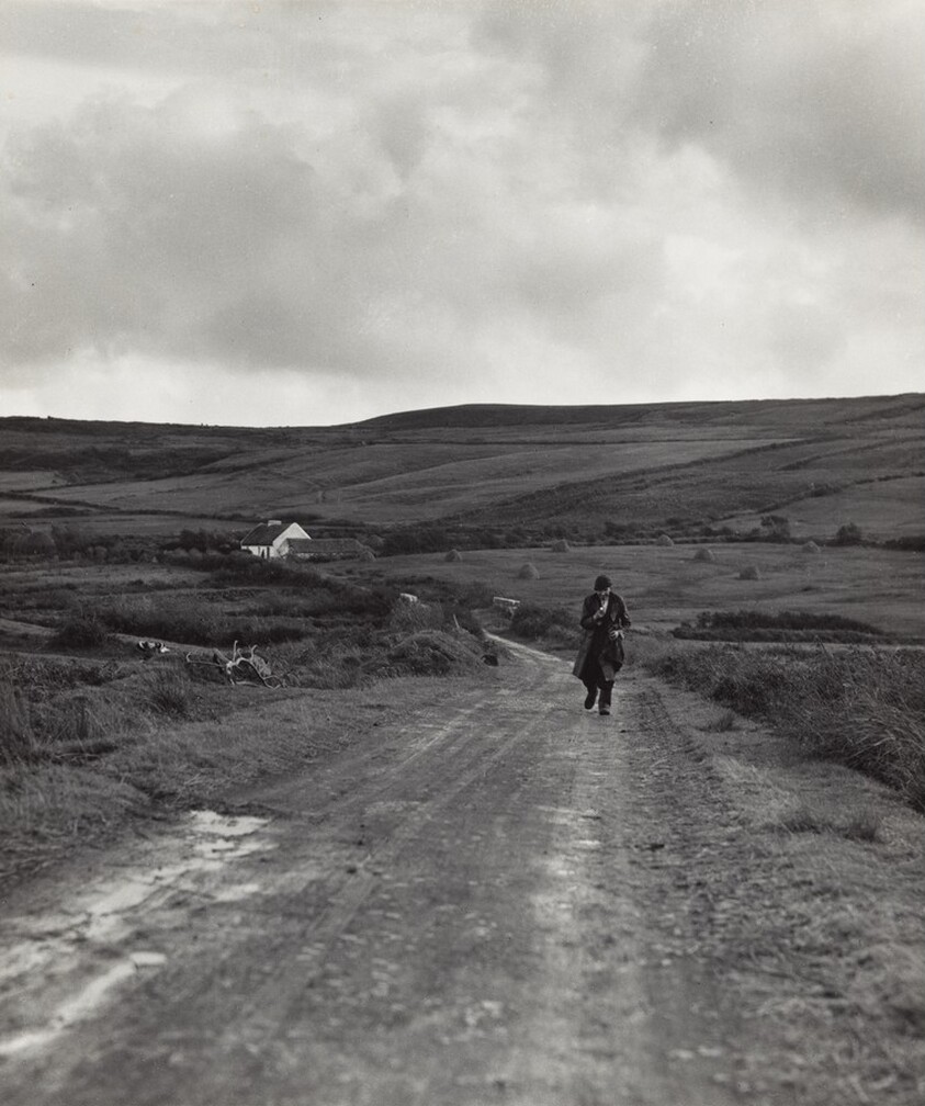 Man walking down a country road from the Kenneally family farm, County Clare, Ireland
