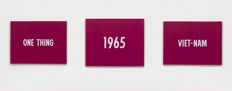 Three horizontal paintings with raspberry-pink backgrounds and white text hang spaced out in a row against a white background. The central panel is slightly larger than those hanging to the sides. The white text on the left panel reads, “ONE THING.” In the center is “1965,” and the panel to our right has, “VIET-NAM.”