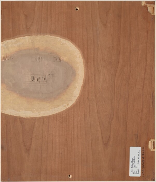 The image depicts the reverse side of a wooden panel piece. The back of the panel is medium brown with visible grain patterns. There is an oval patch at the center revealing lighter shades of wood, with rough engraved text reading "Duch." Two small circular holes are drilled through the panel at the top and bottom. A label with black text is affixed at the lower right edge, detailing the artist as Richard Estes, along with the title, date, and place. The panel appears utilitarian in nature.