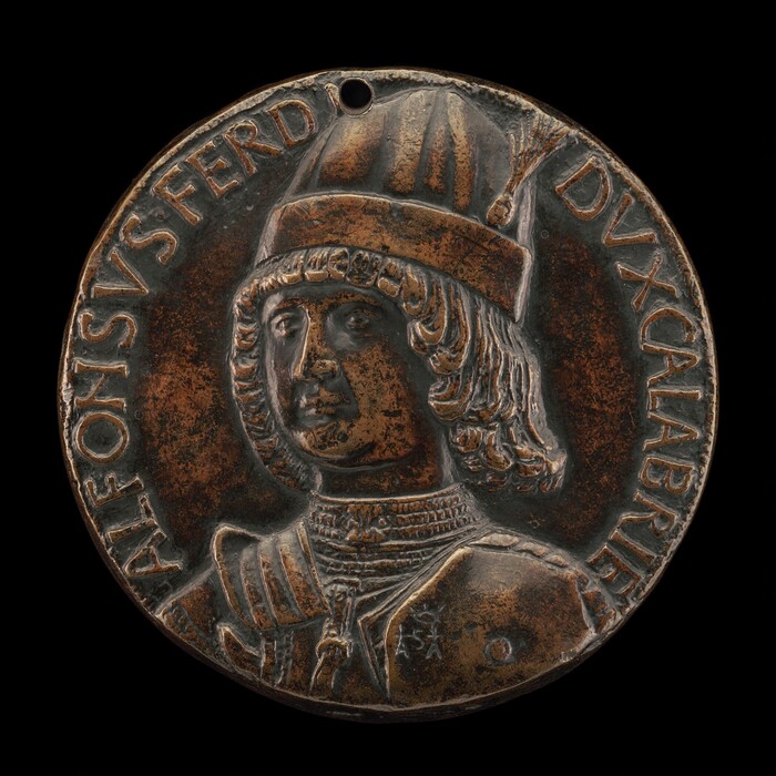 The sculpture is a round bronze medal with a relief portrait of a man in profile. The subject is wearing a hat with a crest and ornate collar, suggesting historical or noble significance. The bronze material gives the sculpture a dark brown color with subtle highlights. It is small and detailed, with text encircling the portrait for contextual identification.