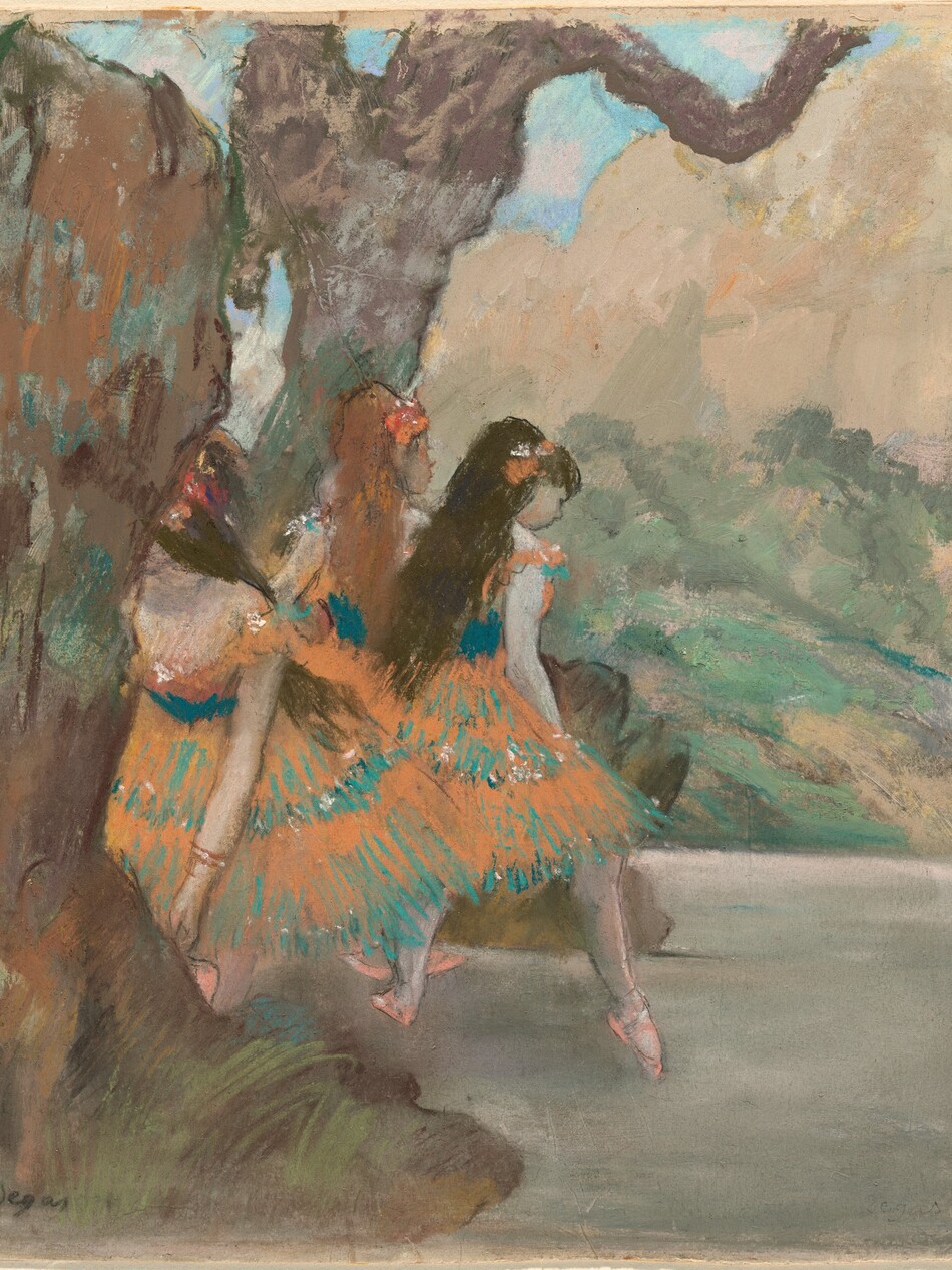 Three pale-skinned ballet dancers wearing orange and dark turquoise costumes stand together on a stage in this square composition, which is painted with gouache and drawn with pastel over a monotype print. The dancers are close together near the center of the drawing, between two scrims representing trees, bushes, and grass on the theater set. A backdrop beyond suggests bushes and a tan-colored mountain under a blue sky. Two ballerinas face away from us. The dancer to the left has long, copper-red hair, and the one to the right has long brown hair. That second dancer leans onto one pointed toe. The third dancer, also with brown hair, is closer to and faces us, but she bends forward to adjust one shoe, and her face is hidden behind the stage setting. All three have peach-colored flowers in their hair, and their costumes have knee-length tutus with alternating layers of orange and turquoise. Swag sleeves lie across the dancers' upper arms from their low-cut bodices, and all three wear pale pink ballet slippers. The scene is drawn and painted with loose, visible strokes of paint and pastel, making many details indistinct. The artist signed the lower left corner, “Degas.”