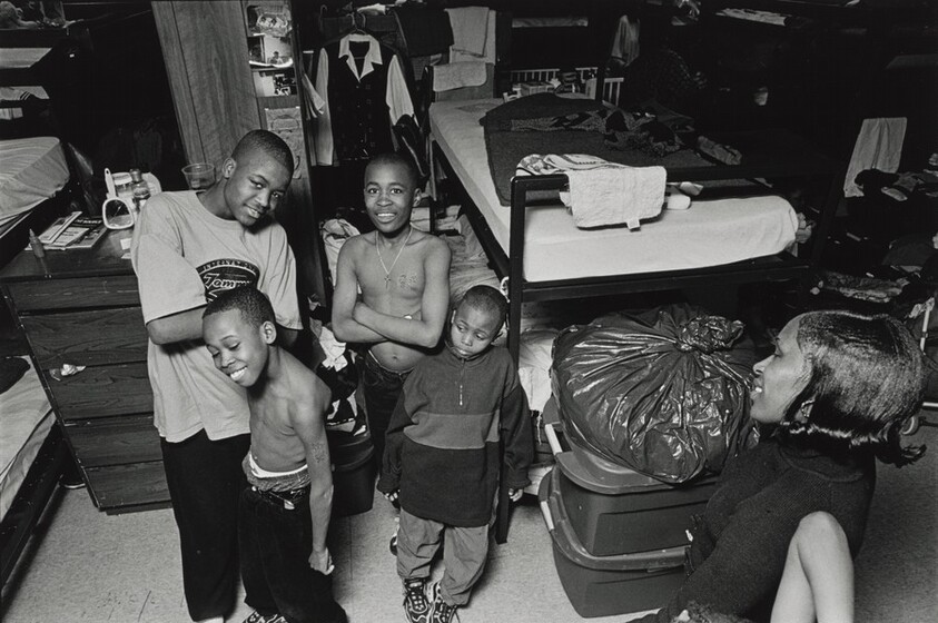 Standing between their bunk beds, Margie admires her four sons: Johnny, 13, Pierre, 11, Jamont, 9, and Johnnell, 11. She always took care of her kids until she fell in love with a drug addict and became addicted herself. Her children's world fell apart and they became homeless residents at the mission. Olive Branch Mission, Chicago.