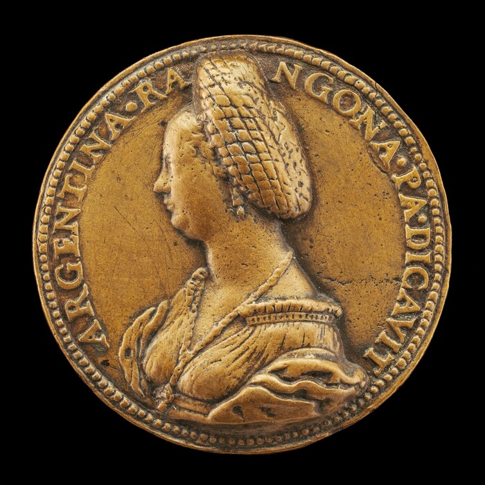 The sculpture is a relief representation of a woman's bust in profile, facing left. She wears a fabric hat and a textured dress with a low neckline, gathering, and pleats. She also wears a necklace and the sculpture is made from a golden-brown material, possibly bronze. It features a raised inscription in capital letters, giving a formal context to the piece. The sculpture has a polished finish, enhancing its details and giving it an antique quality.