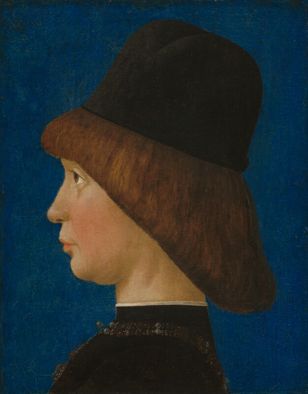 Shown from the shoulders up, a pale-skinned boy faces the left in profile against a lapis-blue background in this vertical portrait painting. He stares steadily forward with brown eyes, rosy cheeks, and closed pink lips. His chin is pulled slightly down and back. The boy's brown hair falls from bangs across his forehead in a straight, diagonal line to the nape of his neck. He wears a brimless black cap with a high, rounded crown. His high-necked, black garment has gold, black, and pearl embellishments around the neckline and down the front. The collar is edged with white along the top.