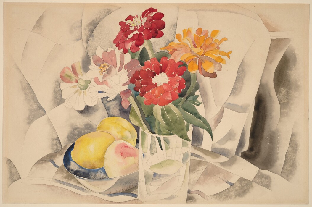 The image shows a glass vase with colorful flowers and a blue-rimmed plate with yellow and pink fruits. A soft background in muted colors complements the bright and warm colors of the flowers and fruits. The vase is positioned slightly right of center, with the plate on the left in the foreground.