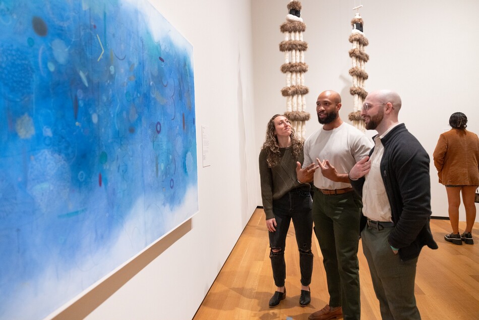 Visitors look at a painting in the National Gallery of Art.