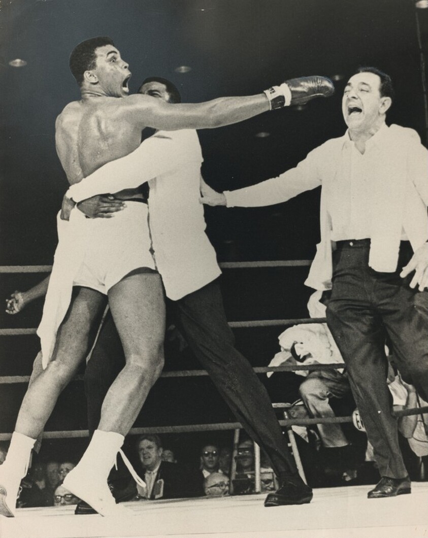 Title from caption on object: “Ali Acts Up After First Liston Fight Victory in Miami...”