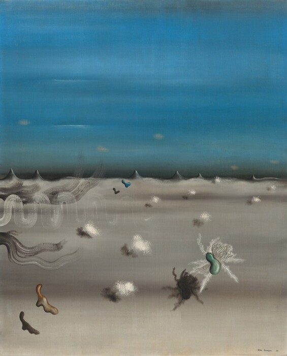 A sky streaked with azure blue stretches over a gray landscape in this surreal, vertical painting. The sky and land meet halfway up the canvas at a series of short, sharp, charcoal-gray peaks, like canine teeth. Small, diffuse, butter-yellow ovals waft above the peaks. Nine fluffy, cotton-ball like shapes cast narrow shadows across the gray-streaked plane. Three amorphous shapes float over the land closer to us. A ginger-brown, drippy form is to our left, a teal-green, bean-shaped object surrounded with fuzzy white tentacles is to our right, and a peacock-blue, L-shaped drip floats in the distance near the horizon. Thinly painted white and gray lines squiggle or sweep onto the canvas from the left edge. The artist signed and dated the painting in the lower right, “Yves Tanguy 29.”