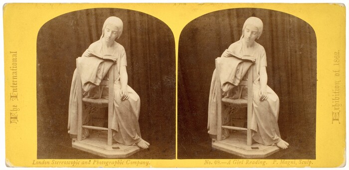 The sculpture depicts a girl engrossed in reading a book while seated, with one leg extended and almost touching the floor. Her head is slightly tilted downward, and her gaze is fixed on the open pages before her. She is draped in a flowing garment that extends over the sides of her chair. Surrounding the girl, the chair appears intricately crafted, with a woven seat and sturdy legs that support both her and the book she holds. The sculpture is crafted from a light-colored material, likely marble, giving it a smooth, polished appearance that highlights the delicate features of the figure, including her serene facial expression and finely detailed attire. This artwork captures the sense of stillness and focus associated with reading, as the girl remains absorbed in her activity, indifferent to the world around her. This piece is presented in a stereoscopic format.