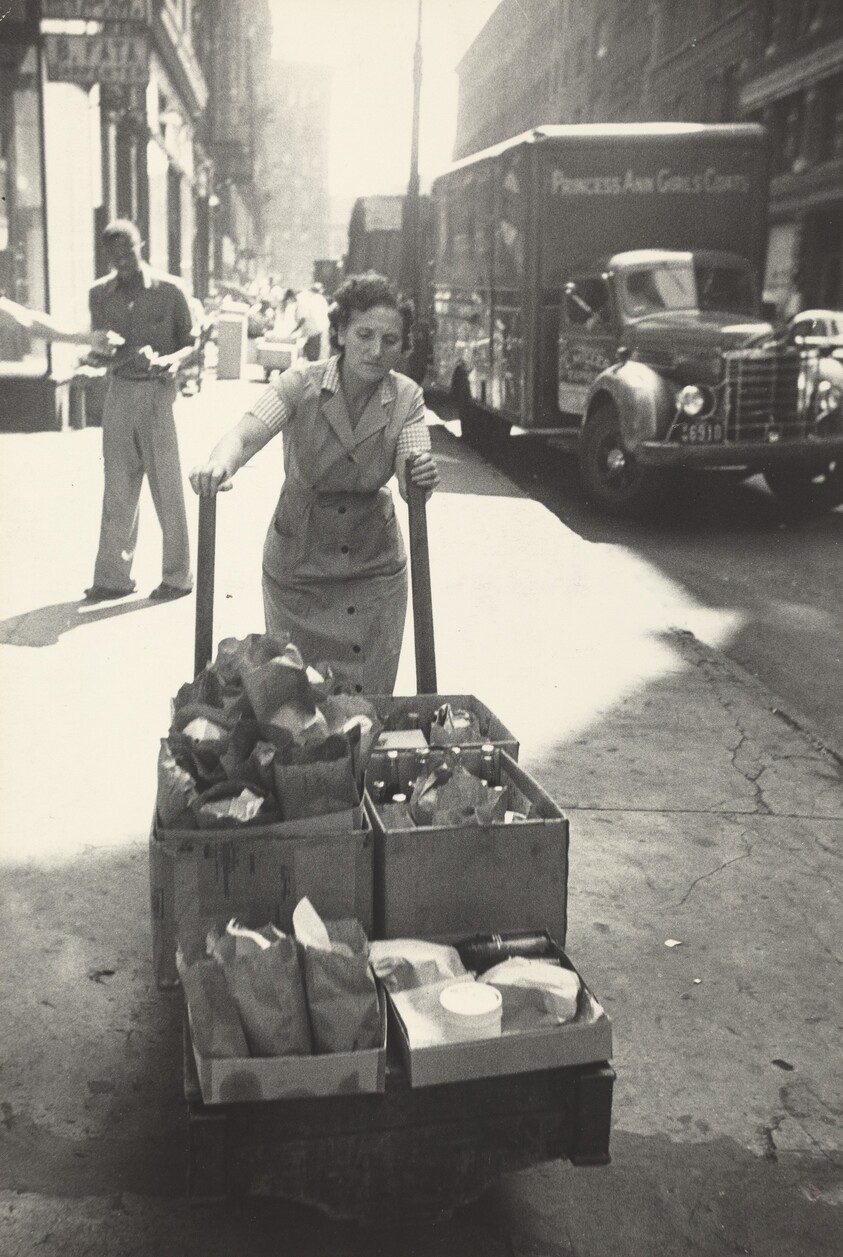 Just before noon Lena Kansler delivers orders to the building at the west corner of the block.  Her husband Benny runs the luncheonette.