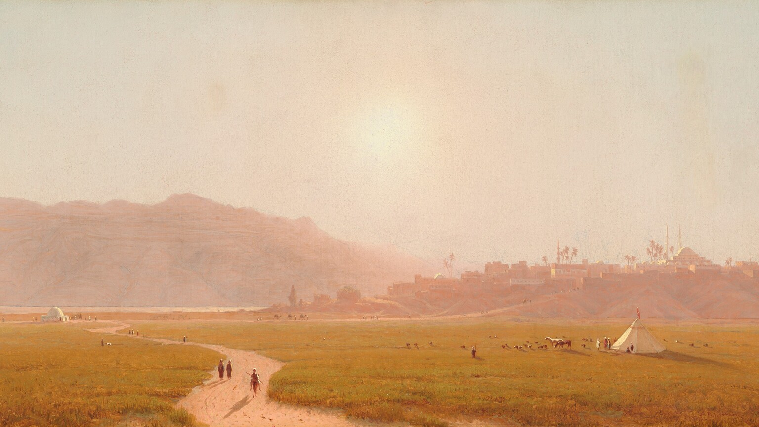 A dirt path winds through a field of gold-green grass back to a town built on low hills in this horizontal, densely hazy landscape painting. Several minuscule people walk on the path and at least one person rides a horse. More people are gathered by a domed, white structure in the distance, where the winding path meets a straighter road leading up into the town near the left edge of the canvas. At least six people sit or stand near a conical white tepee to the right, in the lower quadrant. Two horses and about two dozen smaller animals graze nearby. In the town, the cluster of low, flat-topped buildings, the one domed building with two slender minarets, and palm trees are painted in tones of muted mauve pink and peach. The sun is painted as a hot blaze of light low in the washed-out sky over rocky mountains, which stretch across the left half of the composition. The artist signed and dated the painting with angular red letters in the lower right corner, “S.R. Gifford 1874.”