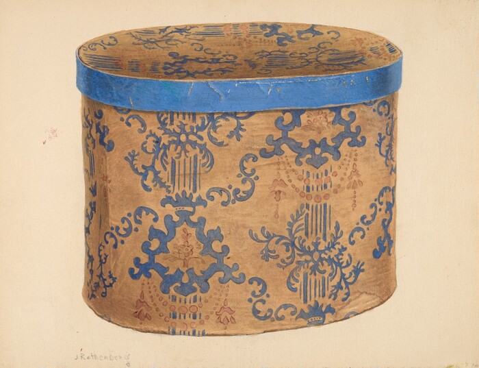 The image shows a large oval-shaped decorative box with a slightly domed lid. The box is adorned with a blue and tan pattern featuring classical motifs. The color palette is mainly shades of blue and tan. The box is centrally positioned in the image, showcasing its intricate design on both sides and the top of the lid.
