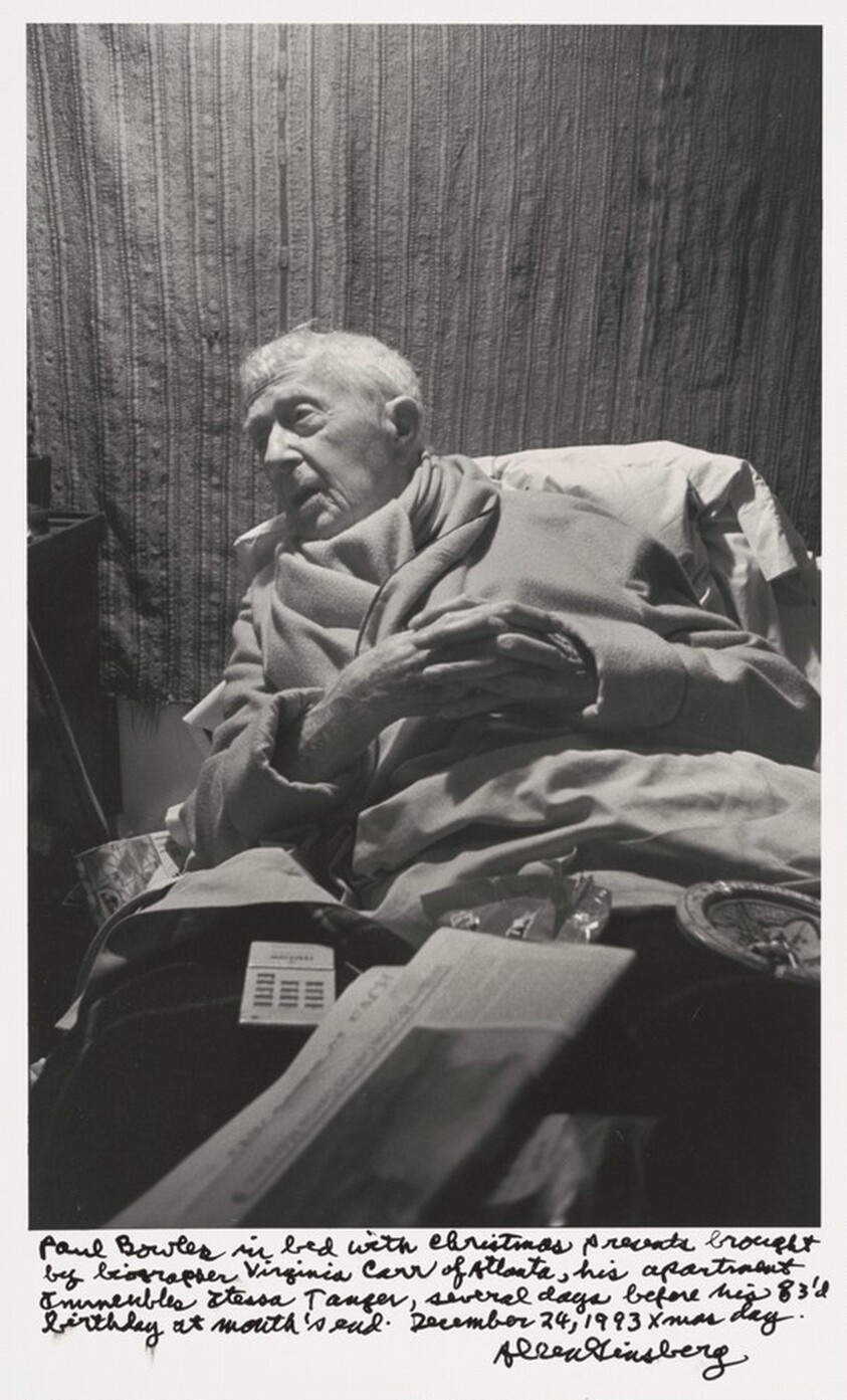 Paul Bowles in bed with Christmas presents brought by biographer Virginia Carr of Atlanta, his apartment Immeuble Itesa Tangier, several days before his 83'd birthday at month's end. December 24, 1993 xmas day.
