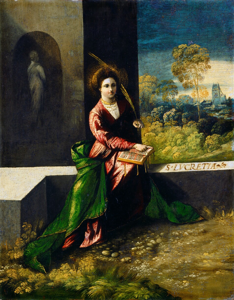 This painting shows a woman seated outdoors, looking towards the right. She has a fair complexion, a round face, and dark brown hair styled back under a large gold headdress. She wears a pinkish-red gown with a green cloak or blanket around her skirts, and she holds a golden palm frond in one hand and points to an open book that rests on her knees with the other. She has a gold necklace or small collar around her neck and a halo of small golden dots around her head. The background on the left features a gray building in shadow, with a tall gray statue standing in a niche. The background on the right features green trees and distant blue buildings under a dark blue sky that is lighter at the horizon. The ground is covered with grass and small stones, and she sits on a flat gray surface.