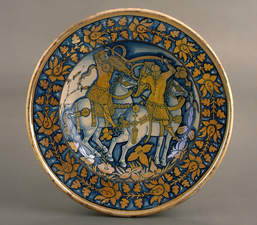 Large dish with running plant border; in the center, horsemen fighting