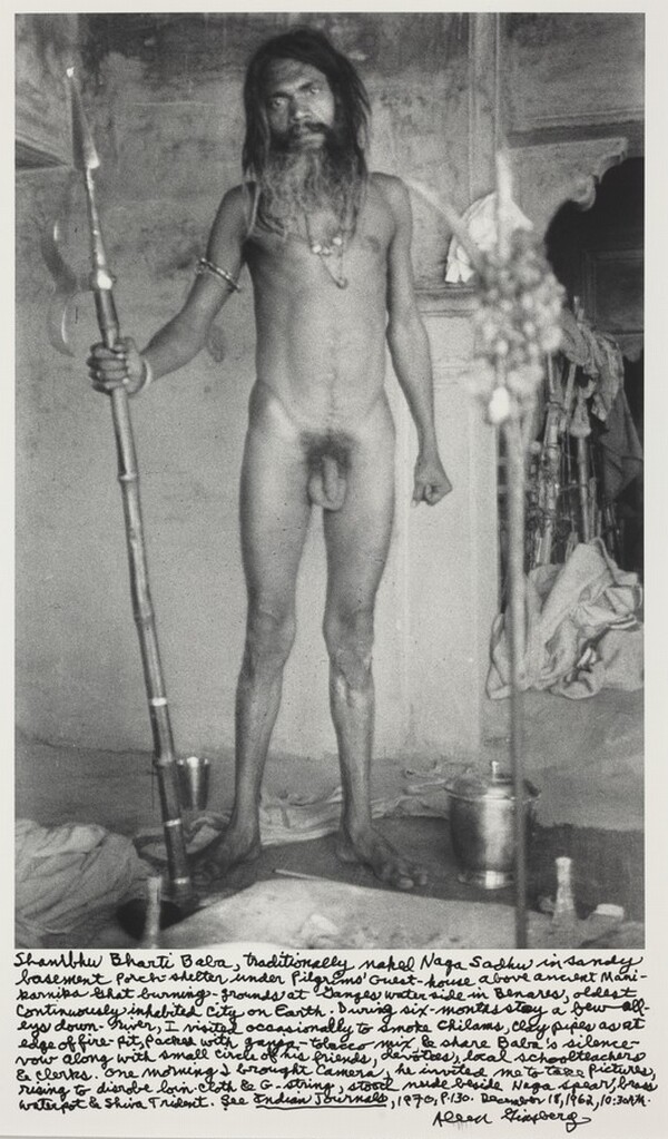 Shambhu Bharti Baba, traditionally naked Naga Sadhu in sandy basement porch-shelter under Pilgrims' Guest-house above ancient Manikarnika Ghat burning-grounds at Ganges waterside in Benares, oldest cintinuously inhabited city on Earth. During six-months stay a few alleys down-river, I visited occasionally to smoke chilams, clay pipes as at edge of fire-pit, packed with ganja-tobacco mix & share Baba's silence vow along with small circle of his friends, devotees, local schoolteachers & clerks. One morning I brought camera, he invited me to take pictures rising to disrobe loin-cloth & G-string, stood nude beside Naga spear, brass waterpot & Shiva Trident. See _Indian Journals_, 1970, p.130. December 18, 1962, 10:30 AM.