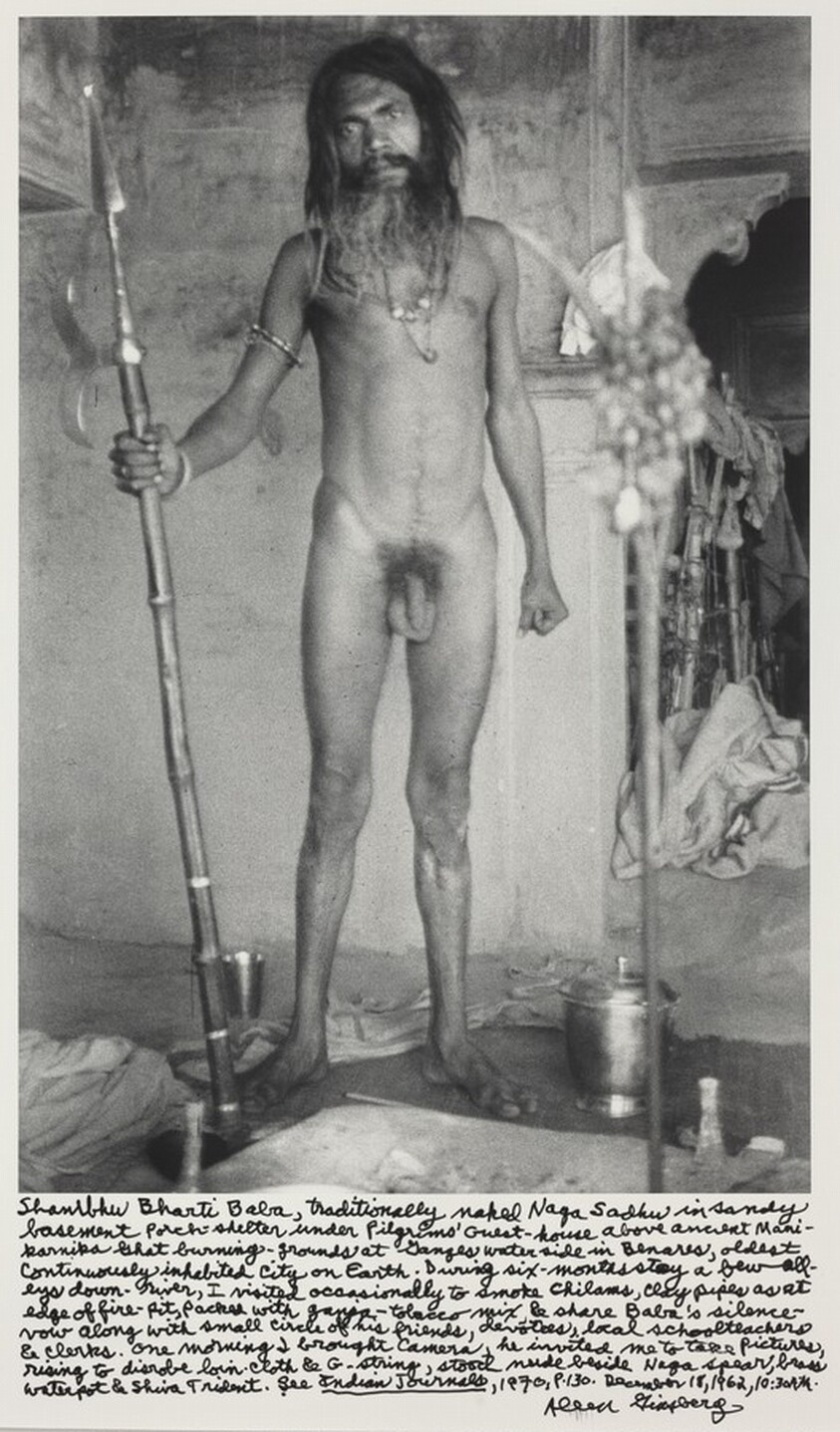 Shambhu Bharti Baba, traditionally naked Naga Sadhu in sandy basement porch-shelter under Pilgrims' Guest-house above ancient Manikarnika Ghat burning-grounds at Ganges waterside in Benares, oldest cintinuously inhabited city on Earth. During six-months stay a few alleys down-river, I visited occasionally to smoke chilams, clay pipes as at edge of fire-pit, packed with ganja-tobacco mix & share Baba's silence vow along with small circle of his friends, devotees, local schoolteachers & clerks. One morning I brought camera, he invited me to take pictures rising to disrobe loin-cloth & G-string, stood nude beside Naga spear, brass waterpot & Shiva Trident. See _Indian Journals_, 1970, p.130. December 18, 1962, 10:30 AM.