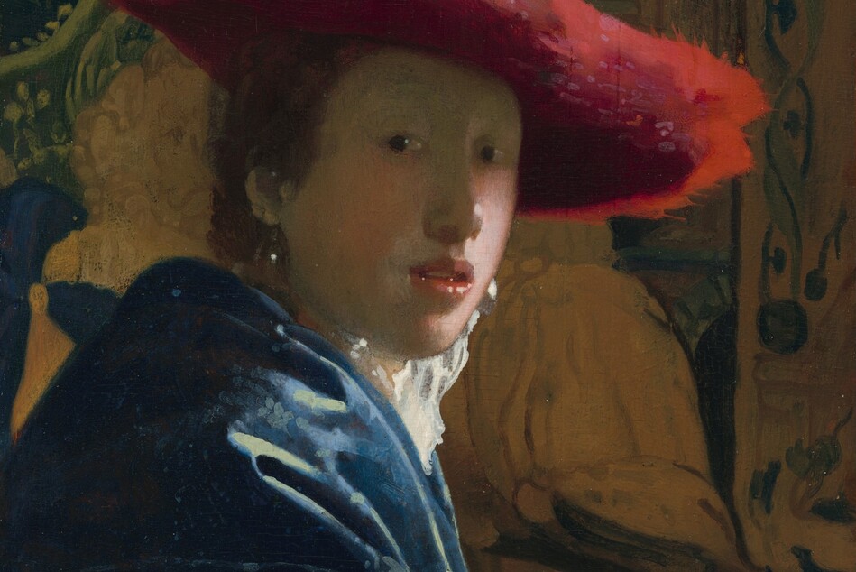 Shown from the elbows up, a young person with pale skin and brown hair wearing a wide, scarlet-red hat sits in front of a tapestry in this vertical portrait painting. She sits with her body facing our right in profile but she turns her face to look at or toward us with dark eyes. She has a rounded nose, rather flat cheeks, and a sliver of teeth is visible through parted coral-pink lips. The wide brim of the red hat seems to be made of a soft, almost feathery material, and it casts a shadow across her face. She wears a high-collared white garment that catches the light, a royal-blue, possibly velvet, robe or overcoat, and large, teardrop pearl earrings. Her arm runs along the bottom edge of the panel in front of two carved, wooden lion finials that could be the arm or back of the chair. The tapestry behind her is painted in tones of pale caramel brown and pine green. The painting has a soft, hazy look, and light glints with bright white specks off the pearl earrings, the tip of her nose, her lips, and the lion finials.