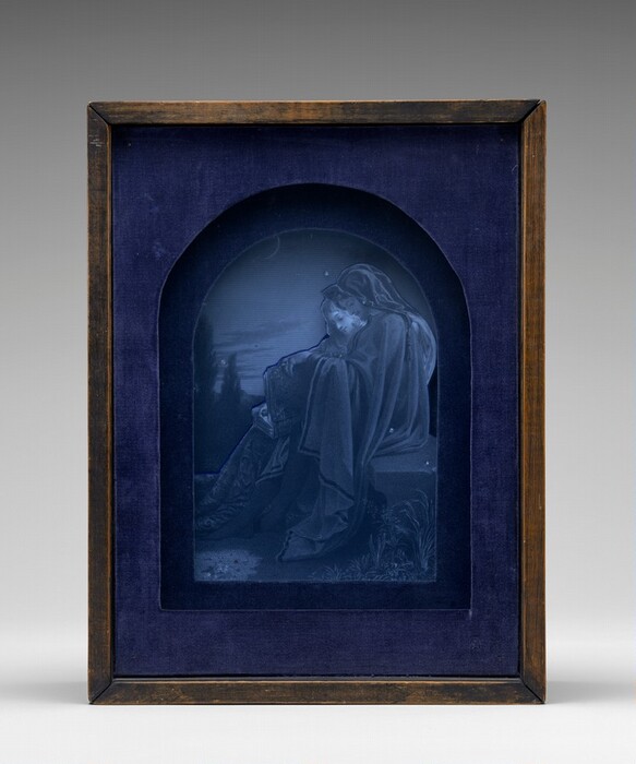 The image depicts a figure in profile, blue and black engraving. The person is seated, head leaning on an arm, eyes closed, with long flowing hair and draped clothing. The figure is surrounded by a halo, with a crescent moon, trees, and cloudy sky in the background. The artwork is framed by a dark blue fabric and wooden frame.