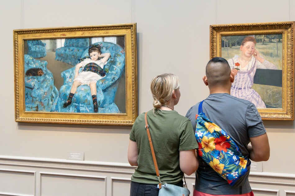 Visitors looking at a painting in the National Gallery of Art.