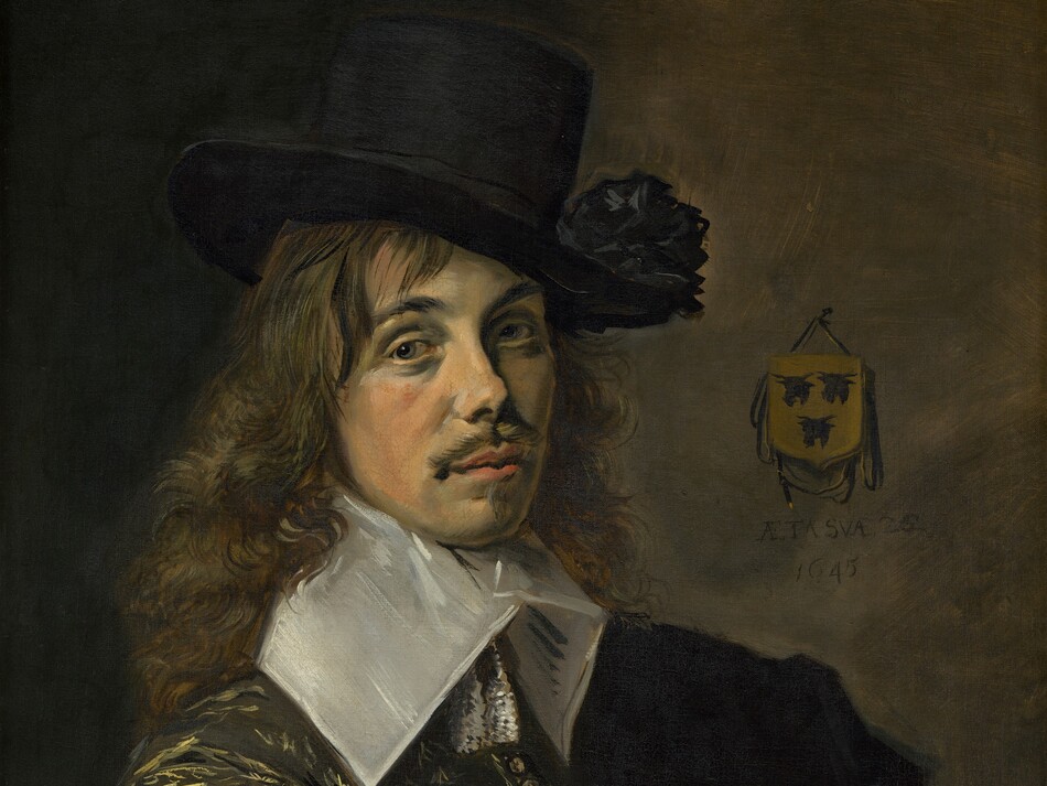 Shown from the waist up, a light-skinned man sits sideways in a wooden chair so the arm closer to us rests along the chair’s back in this vertical portrait painting. Brushstrokes are visible throughout, especially in the clothing and hair. The man’s right arm, to our left, drapes across the back of the chair. His face turns slightly to our right, and he looks at us with gray eyes under black, curving brows. He has an oval face with high cheekbones and a snub nose. His coral-pink lips are closed and framed by a mustache and pointed patch of hair under his lower lip. He is lit from our left so the far side of his face is in shadow. His loose, curly brown hair cascades over his shoulders. He wears a tall black hat with a stiff, wide brim with a black rosette or pompom on the brim to our right side. The hat is tipped slightly to one side so it angles away from us. A flat, stiff, white collar extends from his chin down to his shoulders, and two tassels hang at this throat. The voluminous sleeve along the back of the chair has a gold pattern picked out in loosely painted, swirling, feathered, and flaring lines against a black background. The jacket is unbuttoned along the forearm to reveal a stark white undershirt that is gathered with a narrow ruffle at the wrist. The chair has a crimson-red center framed by wooden rails to each side and along the top. The background is earth brown to our right of the man, and deepens to dark shadows along the left. A coat of arms, the size of the man’s palm, hangs from the back wall. Three black cow heads create an inverted triangle on a gold field. Under the coat of arms the artist inscribed, “AETA SVAE.22 1645.”