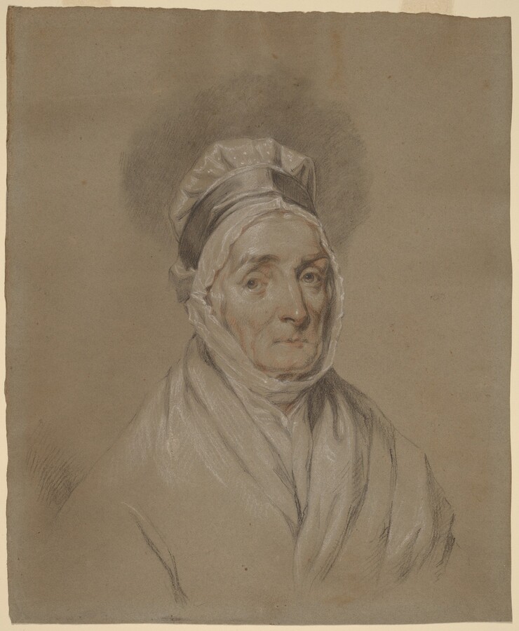 The image is a portrait of an elderly woman shown from the shoulders up. She is facing the viewer with a neutral expression. She has light-colored hair mostly covered by a white bonnet tied under her chin. The woman wears a light-colored garment around her shoulders and neck. The background is soft and neutral, providing no context.