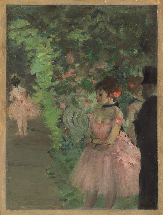 We look slightly down onto a loosely painted scene with three ballerinas in rose-pink costumes and one man, wearing a black suit and top hat, against a backdrop made up of dabs and strokes of lime, mint, and pine green in this vertical painting. The people all appear to have light skin. The most defined person is the woman closest to us, shown from the knees up to the right of center. Her body is angled to our left, and her profile faces that direction. Dark eyelashes suggest her eyes are closed. She has a pointed nose, and her red lips are closed. Dark brown hair is pulled up into a large bun with a coral-pink flower tucked in at the back of her head. She grips opposite elbows at her waist, her arms close to her body. Her pink costume has a low-cut bodice with loops low over her shoulders and a flaring, knee-length tutu. She wears a black choker tied with a bow at the back of her neck and two black bands encircle her wrists. A touch of white at the ear we can see suggests a gold earring. To our right and cut off by the right edge of the painting, a man stands beyond the woman’s shoulder, in shadow as he looks onto the scene. His face is painted with taupe-gray strokes. His suit and top hat are black except for a narrow white collar at his neck. Beyond this pair and seen from the chest up between them, another woman in the same pink costume faces our right. A short distance from us to our left, a third ballerina stands facing away from us. The elephant-gray floor she stands on visually creates a vertical band up the left side of the composition. The rest of the space behind and around the man and dancers is painted loosely with shades of vibrant to muted greens, with a few dabs of pale pink. The painting has a narrow sand-brown border. The artist signed the work by incising into the green paint in the upper right corner, “Degas.”