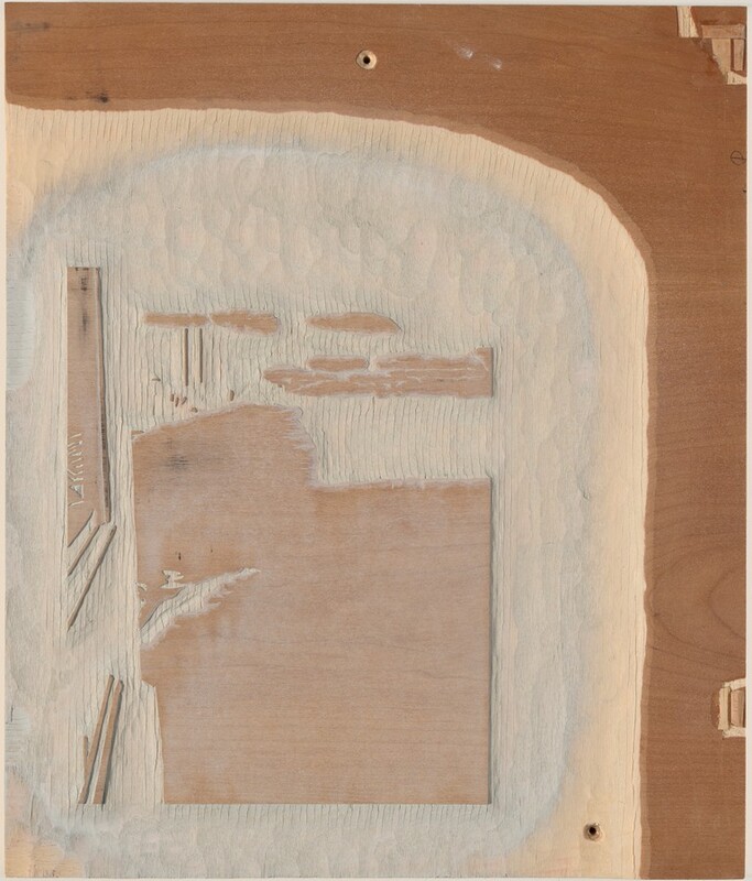 The sculpture is a relief carved into a flat wooden board, featuring abstract and rectangular shapes etched and grooved into the surface. The board displays a natural wooden color palette, ranging from light tan to deeper brown tones. The texture of the wood and the varying depths of the carvings create a tactile appearance. In relation to the viewer, the sculpture appears to be a detailed section of woodworking. The textures range from smooth to rough, with some areas having a scratched or chipped appearance. Small openings or holes are visible, which could relate to the assembly or design of the piece. Overall, the piece presents itself as a study in geometric shapes and textures emphasized by the natural aesthetics of wood.