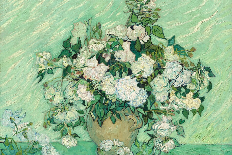 A profusion of white roses bursting from the neck of a tan jug almost fills the height of this horizontal still life painting. The roses have large, round blooms with petals tinged with denim and aquamarine blue, sage green, mauve pink, teal, and butter yellow. Emerald-green leaves fill the spaces between blossoms. The jug has a short, rounded handle and sits on a sea glass-green surface. A few blooms lie in the lower left corner and at the foot of the vessel. Many of the flowers, leaves, and vase are outlined with navy blue or black. A mint-green wall with wavy, diagonal streaks of cream white fills the background. The paint is applied thickly with visible strokes.
