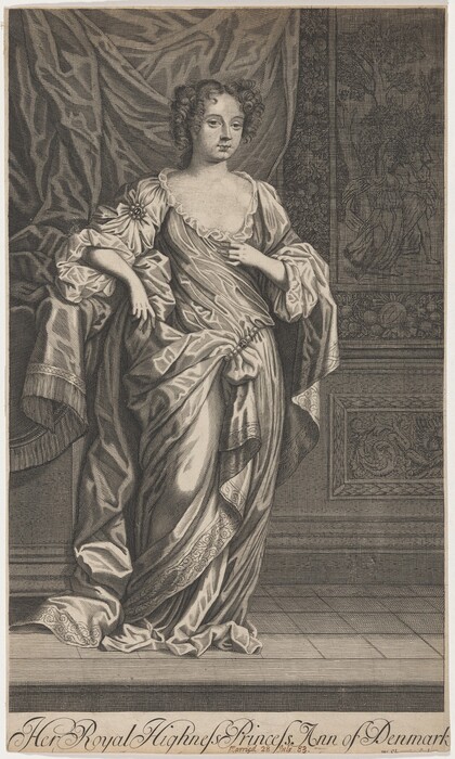 The image displays a woman standing in a full-length portrait. She is slightly turned, with her body facing forward and her gaze averted. The woman has curly hair, delicate facial features, and wears an elegant gown with ruffled sleeves, a floral ornament, and a decorative sash. She poses with one hand on her hip and the other holding the drapery near her chest. The background features a detailed tapestry with tree and figure motifs against a textured backdrop.