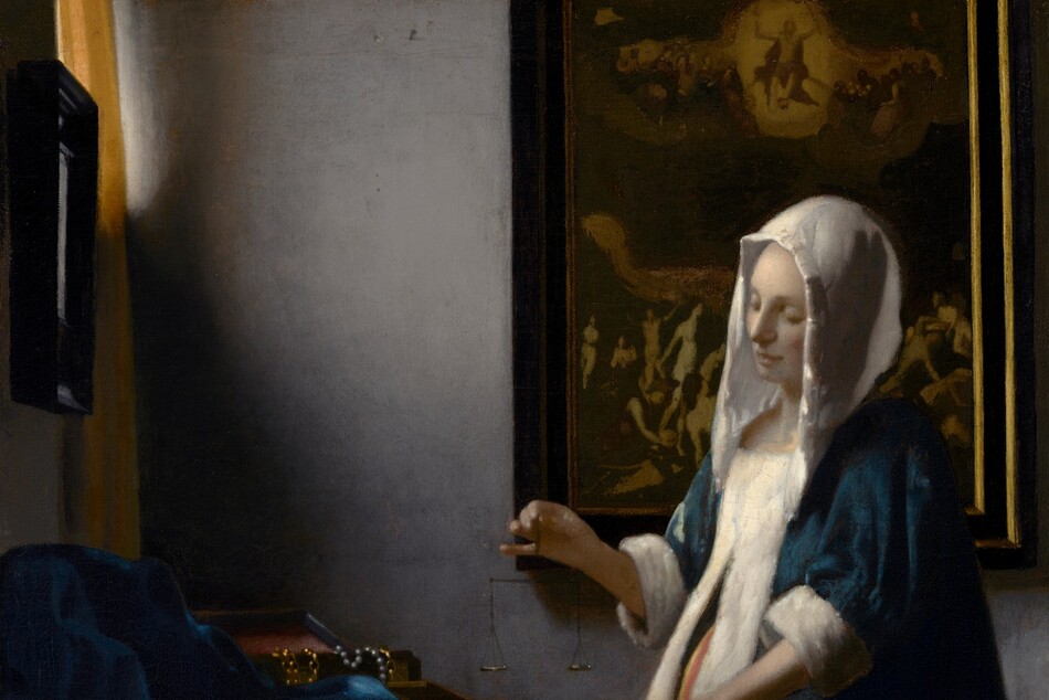 In this vertical painting, a woman stands near the corner of a dimly lit room, facing our left in profile and looking down at a balance she holds suspended in her right hand over a wooden table. She wears a peacock-blue velvet jacket with a white hood and fur lining, and a voluminous, mustard-yellow skirt. A window near the upper left corner is partially covered by a canary-yellow curtain. Light coming in through that window falls on the pale skin of the woman's face and hands, and highlights the white trim of her garment. Her left hand, closer to us, rests on the edge of the table near two open boxes, and a blue cloth is bunched at the back of the table to our left. Gold chains and pearl strands drape over the edge of one box. The woman stands in front of a framed painting. Much of the detail is lost in shadow but at the top center of the painting, a person surrounded by a golden halo floats in the sky with both arms raised, and is flanked by people encased within a bank of clouds. Nude people on the ground below in the painting, seen to either side of the woman, writhe, twist, and point upward.