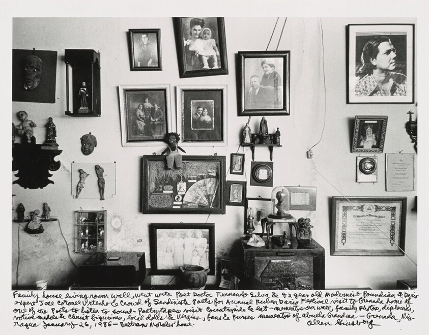 Family house living room wall, went with Poet Doctor Fernando Silva & 82 year old Modernist Poundian & Dario expert Jose Coronel Urtecho & Crowd of Sandinesta Poets for Annual Ruben Dario Festival visit to Grenada home of one of the poets to listen to sound- Poetry tapes visit Countryside & eat- mementos on wall, family photos, diplomas, votive medals & Christ figurines, local dolls & Virgins, fans & purses mementos of Abuela Grandma-- Grenada, Nicaragua January 26, 1986-- Beltran Morales' home.
