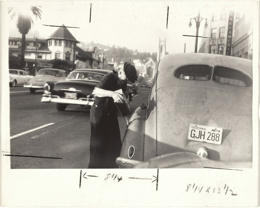 Elderly woman pumping gas--Los Angeles