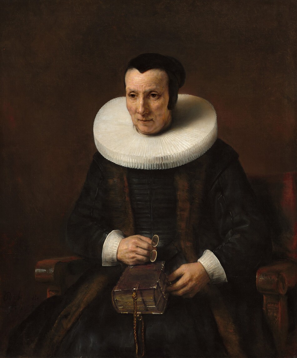 Shown from the knees up, a pale-skinned woman wearing a black dress with white cuffs and a wide, starched collar sits in a wooden chair against a dark brown background in this vertical portrait painting. Her body faces us and she looks off to our left with brown eyes. She has slight jowls at her chin and her eyes, mouth, and forehead are lined. Her hair is pulled back under a close-fitting black cap. Extending straight from around her neck, her white collar is pleated into narrow figure-eights and nearly reaches her shoulders. She wears a brown stole over her velvety black dress, and both nearly blend with the dark background. She holds a pair of pince-nez spectacles in her right hand, which rests on a thick book in her lap. The spine faces her right, and the opposite edge is fastened with metal clasps. A braided cord affixed to the narrow end of the book near us creates a loop.