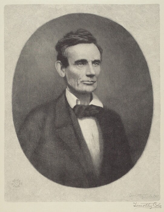 The image shows a portrait of a person from the chest up. The person is sitting upright and facing slightly to the side, looking off to the left. The individual has distinct facial features characterized by high cheekbones, a long, narrow face, and a prominent jawline. Their hair is dark, styled in a short, slightly wavy manner, with a noticeable height at the front. They are dressed in formal attire, wearing a dark suit jacket, a white shirt, and a dark bow tie. The background is a simple, textured oval vignette that frames the figure. There are no visible jewelry or held objects.