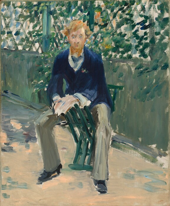 A pale-skinned young man with a carrot-red beard and hair faces us, straddling a green chair in a sunny outdoor setting in this vertical painting. The scene is loosely painted so his features are indistinct. His eyes are painted as pale blue dots, and he looks out at us. His chair unfolds into an X shape, with interlacing slats to make the seat. He leans forward to rest his hands on one side of the chair, and his legs are spread wide. He wears a marine-blue jacket over a white shirt, sage-green trousers streaked with gray, and black shoes. A soft blue V-shape at the neck suggests a neckerchief. Behind him, a half wall is topped by a trellis. The wall is painted in muted tones of pale laurel green while the trellis is painted with crisscrossed strokes of pine green. Daubs of emerald, pine, and forest green suggest vines and leaves, and flicks of orange, gold, and blue could be flowers. The ground beneath the man is pale peach scattered with thin scribbles and patches of fog blue. The painting is inscribed with “E 72.” in the lower right.